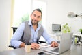 Portrait of handsome trendy casual mid age business man in office desk with laptop computer Royalty Free Stock Photo