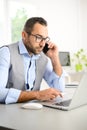 Portrait of handsome trendy casual mid age business man in office desk with laptop computer Royalty Free Stock Photo