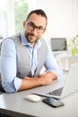 Portrait of handsome trendy casual mid age business man in office desk with laptop computer Royalty Free Stock Photo