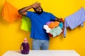 Portrait of handsome trendy exhausted guy hand washing linen in bowl hard isolated over bright yellow color background