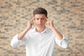 Portrait of handsome troubled young man against brick wall Royalty Free Stock Photo