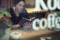 Portrait of handsome white hipster man read a book in cafe near window