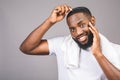 Portrait of handsome young african american black man combing his hair in bathroom. Isolated over grey background Royalty Free Stock Photo