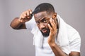 Portrait of handsome young african american black man combing his hair in bathroom. Isolated over grey background