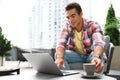 Portrait of handsome young -American man with laptop and cup of drink in outdoor cafe Royalty Free Stock Photo