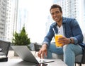 Portrait of handsome young African-American man with laptop and glass of juice in  cafe Royalty Free Stock Photo