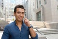 Portrait of handsome young African-American man talking on mobile phone outdoors Royalty Free Stock Photo