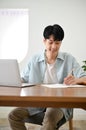 Portrait, Handsome young Asian male college student doing homework, taking notes Royalty Free Stock Photo