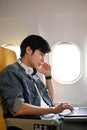 Portrait, Handsome Asian male passenger focused working on laptop during the flight Royalty Free Stock Photo