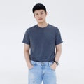 Portrait of a handsome young Asian man with short black hair wearing a black T-shirt and blue jean pants looking at a camera Royalty Free Stock Photo