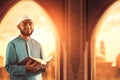 Portrait of handsome young asian muslim man with beard hold holy book quran
