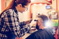 Portrait of handsome young bearded caucasian man getting trendy haircut in modern barber shop. Royalty Free Stock Photo