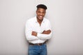 Handsome young black man with arms crossed smiling against gray background Royalty Free Stock Photo