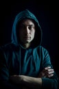 Portrait of a handsome young blue-eyed hooded man with his arms crossed Royalty Free Stock Photo