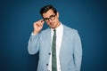 Portrait of handsome young businessman  glasses on blue background Royalty Free Stock Photo