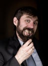 Portrait of handsome young businessman looking through magnifying glass on a brown background Royalty Free Stock Photo