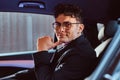 Portrait of a handsome young businessman sitting in the back seat of the luxury car. Royalty Free Stock Photo