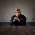 Portrait of handsome young catholic priest praying to God. Dark style, concept doubt Royalty Free Stock Photo