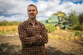 Portrait of young Caucasian handsome happy man farmer standing in field and smiling to camera.