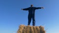 Portrait of a handsome young farmer student sitting on haystack, beautiful smile, in work clothes with airplane in hand. Concept