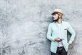 Portrait of handsome young hipster man listening to music against a grunge bricks wall background. Royalty Free Stock Photo