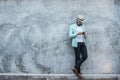 Portrait of handsome young hipster man listening to music against a grunge bricks wall background. Royalty Free Stock Photo