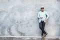 Portrait of handsome young hipster man listening to music against a grunge bricks wall background. Royalty Free Stock Photo