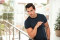 Portrait of handsome young leaning on railing indoors