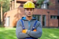 Portrait of handsome young male engineer in hard hat looking at camera, posing outdoors while working on cottage Royalty Free Stock Photo