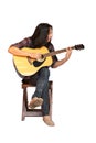 Portrait handsome young male guitarist with long hair sitting and playing acoustic guitar. Asian long-haired man playing acoustic Royalty Free Stock Photo