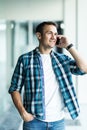 Portrait of handsome young male talking on mobile phone in office. Communication concept Royalty Free Stock Photo