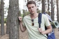 Portrait of handsome young man with backpack hiking in forest Royalty Free Stock Photo