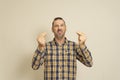 Portrait of handsome young man with beard showing italian gesture meaning what do you want over beige background. A Royalty Free Stock Photo