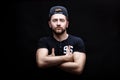 Portrait of handsome young man in black shirt and cap on black background. rapper Royalty Free Stock Photo