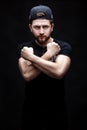 Portrait of handsome young man in black shirt and cap on black background. rapper Royalty Free Stock Photo