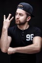 Portrait of handsome young man in black shirt and cap on black background. rapper Royalty Free Stock Photo