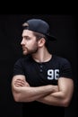 Portrait of handsome young man in black shirt and cap on black background. rapper Royalty Free Stock Photo