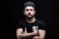 Portrait of handsome young man in black shirt and cap on black background. rapper Royalty Free Stock Photo