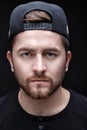 Portrait of handsome young man in black shirt and cap on black background. rapper Royalty Free Stock Photo