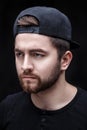 Portrait of handsome young man in black shirt and cap on black background. rapper Royalty Free Stock Photo