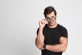 Portrait of handsome young man in black t-shirt  glasses on grey background. Space for text Royalty Free Stock Photo