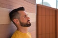 Portrait of handsome young man, with blue eyes and yellow shirt, with his head leaning against a wall very worried. Concept beauty Royalty Free Stock Photo