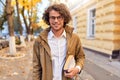 Portrait of handsome young man with books outdoors. College male student carrying books in college campus in autumn street Royalty Free Stock Photo