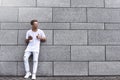 Portrait of a handsome young man in casual clothes enjoying music on your mobile phone, against a brick wall. copy space Royalty Free Stock Photo