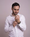 Portrait of a handsome young man. Elegant pose with white dots shirt and touching watch.