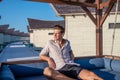 Portrait of handsome young man in expensive shirt at the swing at the tropical island luxury resort Royalty Free Stock Photo