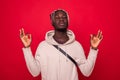 Portrait handsome young man, eyes closed, in meditation zen mode, isolated red background. Stress relief techniques concept take Royalty Free Stock Photo