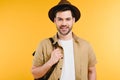 portrait of handsome young man in hat holding backpack and smiling at camera Royalty Free Stock Photo