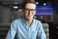 Portrait of a handsome young man, hipster posing with a serious look in glasses, sitting in a cafe, suitable for advertising, text Royalty Free Stock Photo
