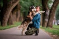 Portrait of a handsome young man and his beloved dog Siberian Husky hugging in nature Royalty Free Stock Photo